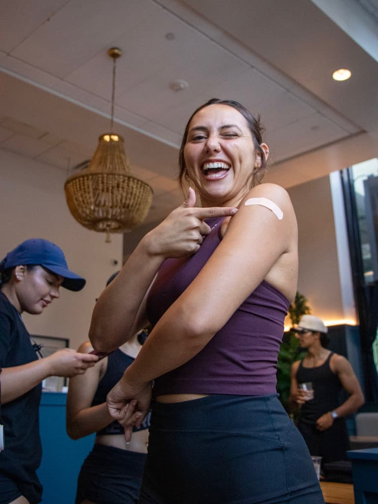 Woman pointing to a band-aid on her arm