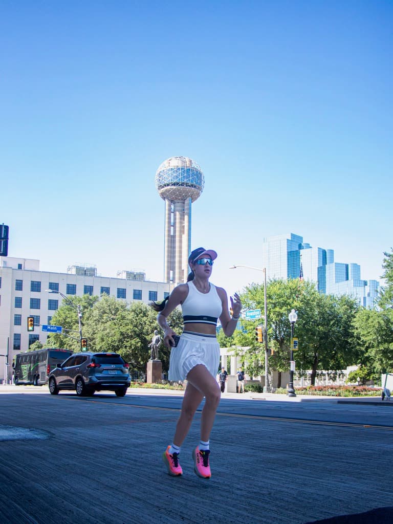 Woman running with the Reunion Tower in the background