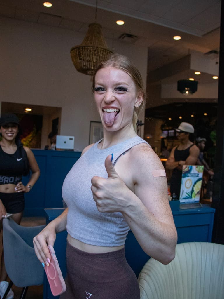 Woman sticking tongue out with a band-aid on her arm