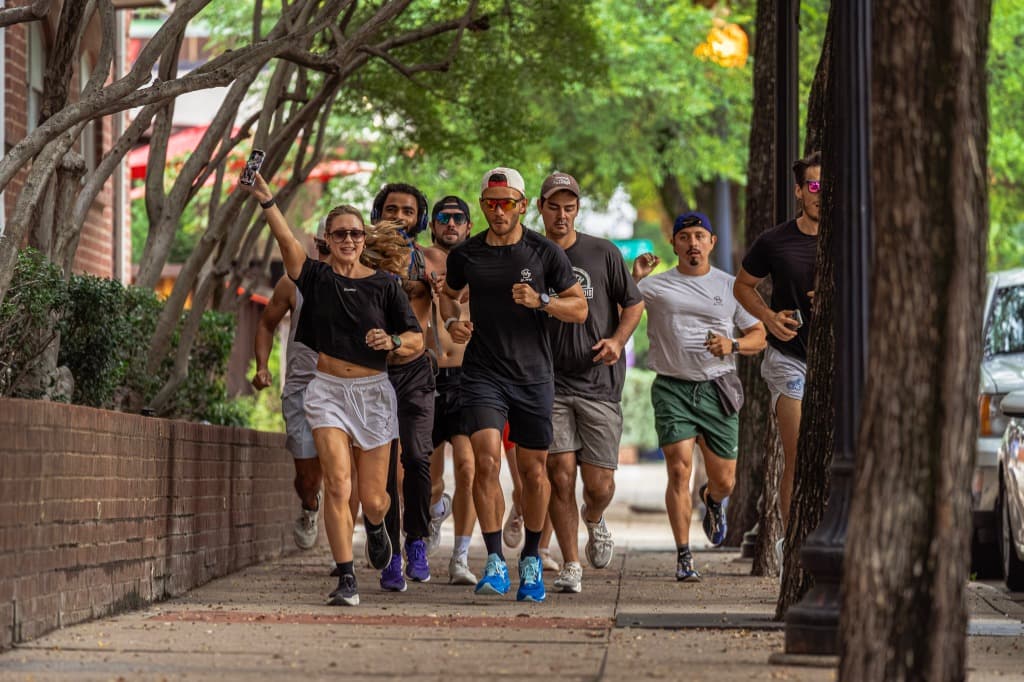 Group running down tree-lined sidewalk